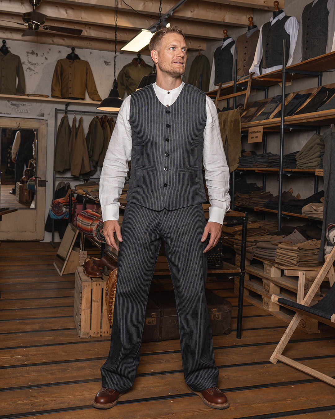 A man wearing a pinstripe navy blue vest with a button-down front and two pockets