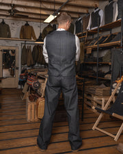 A man wearing a pinstripe navy blue vest with a button-down front and two pockets