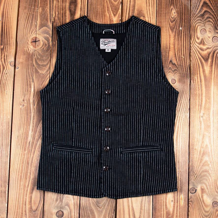 Pinstriped black vest with button-up front and two side pockets, styled against a wooden background, ideal for vintage or western-inspired outfits